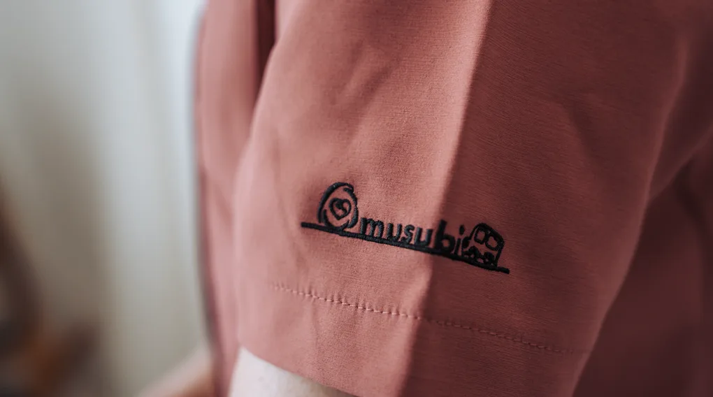 福祉タクシーおむすびのスタッフユニフォームの袖にあしらわれたロゴ刺繍